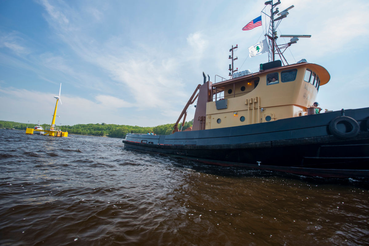 Visual of a US boat towing a floating wind turbine.